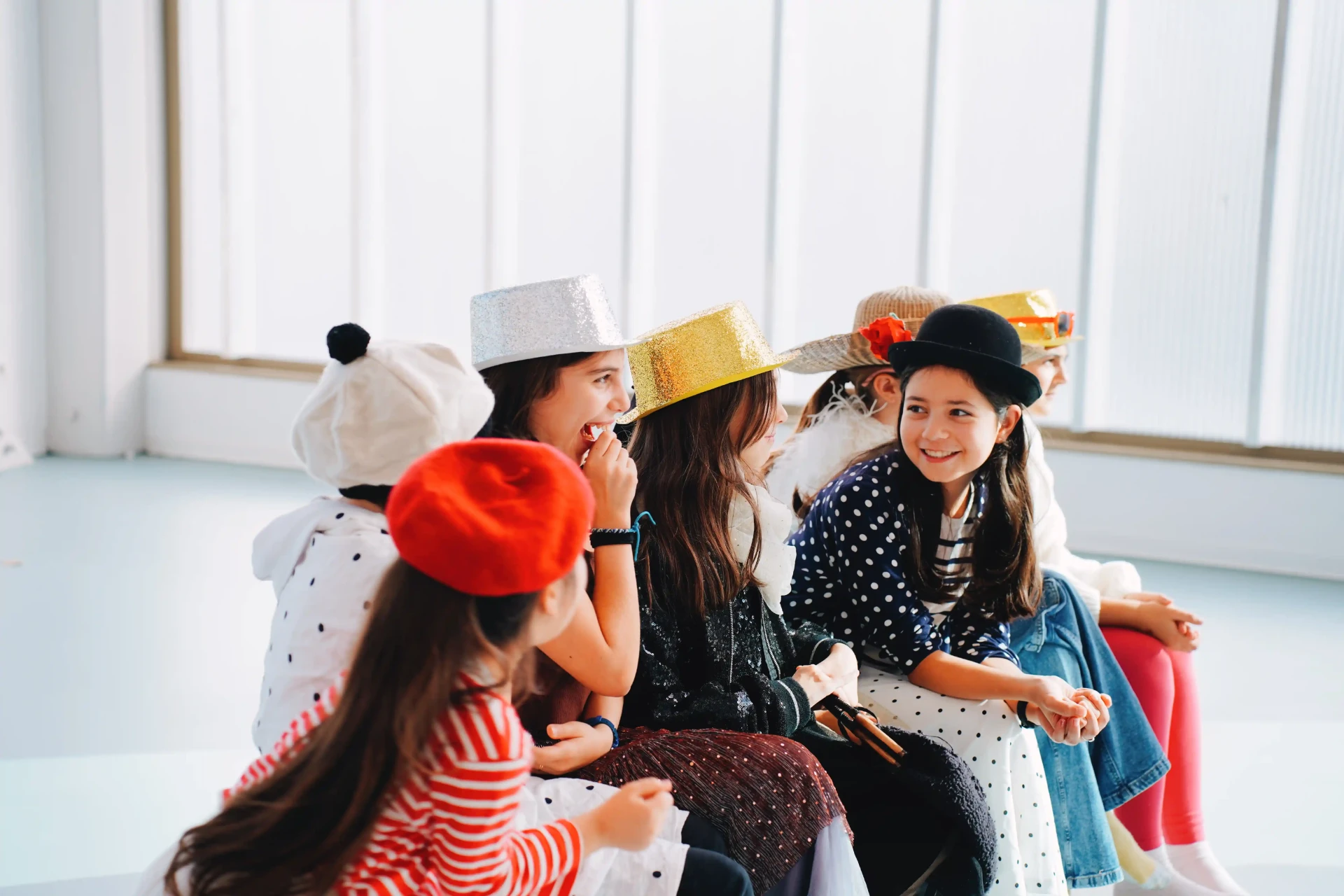 Enfants costumés assis lors d'un cours de théâtre